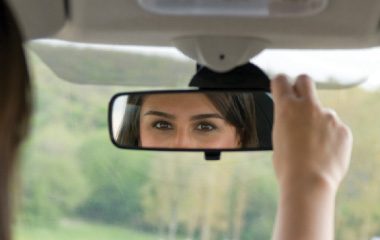 Woman checking rear view mirror
